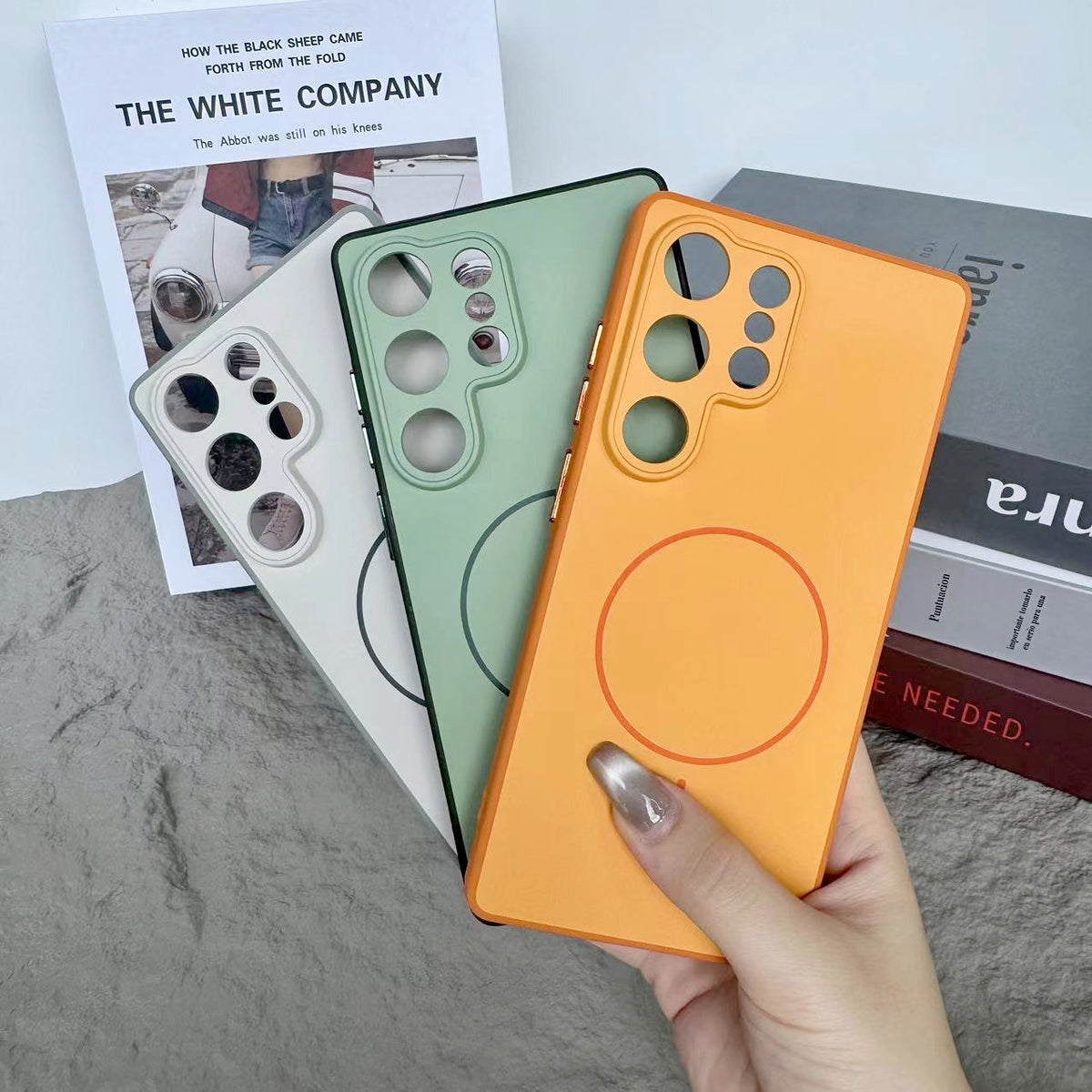 White and orange cases fanned to show dual-tone rims and circular back markings clearly